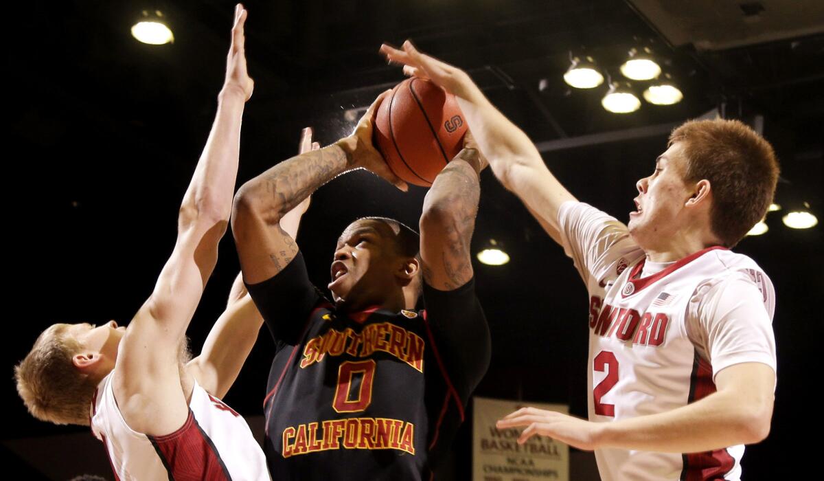 USC forward Darion Clark tries to score between Stanford forward Michael Humphrey, left, and guard Robert Cartwright (2) in the first half Sunday.