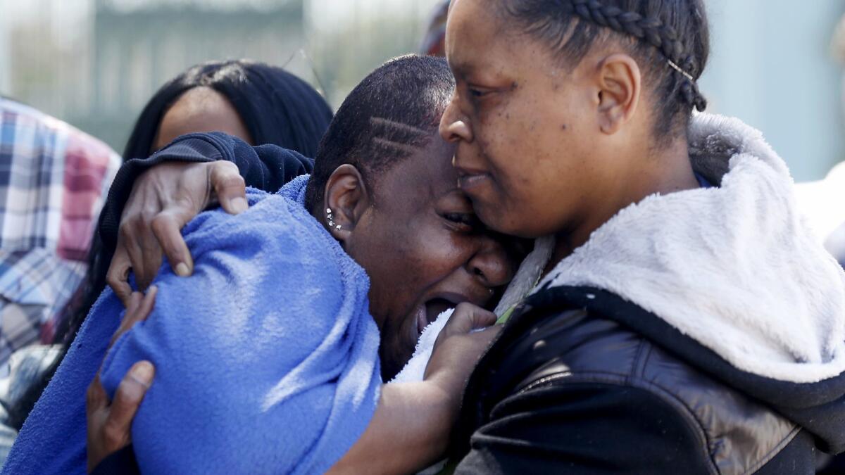 Beverly Owens, left, reacts at press conference, where officials announced a reward of $50,000 for information leading to the arrest of the person who struck and killed Frederick Frazier.