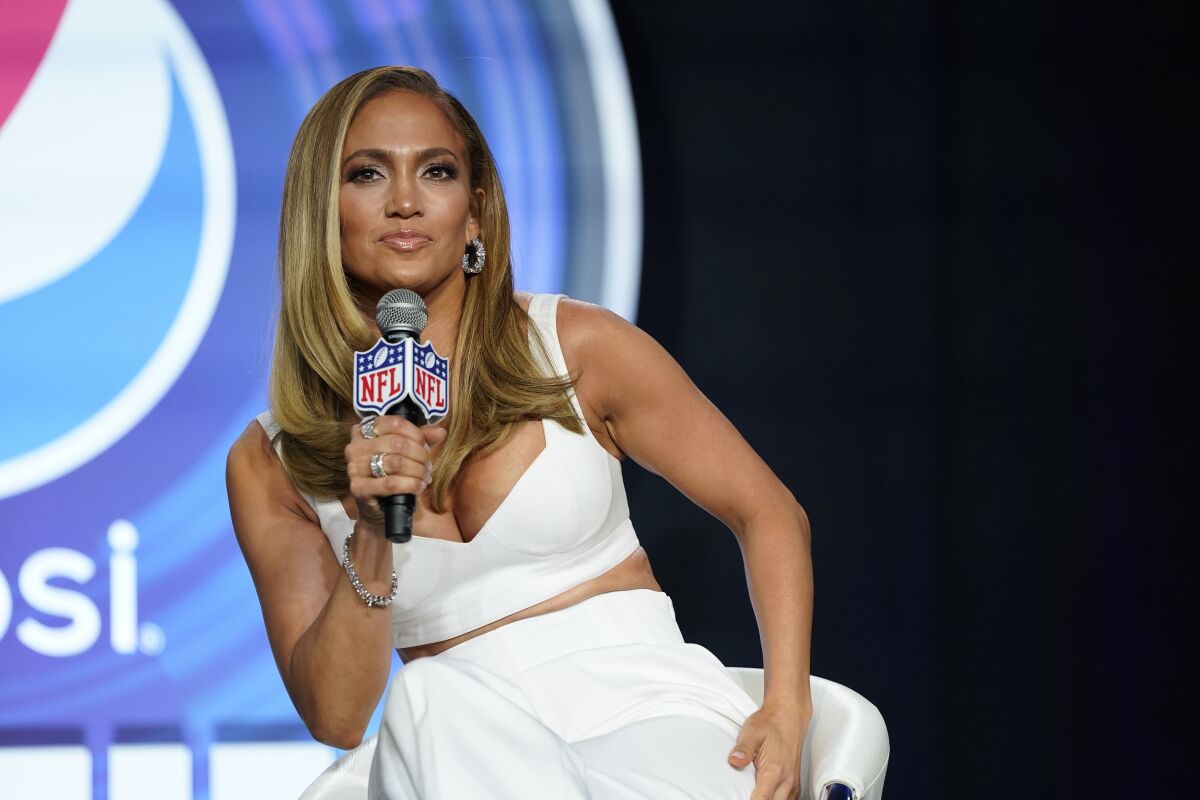 Jennifer Lopez holding an NFL microphone.