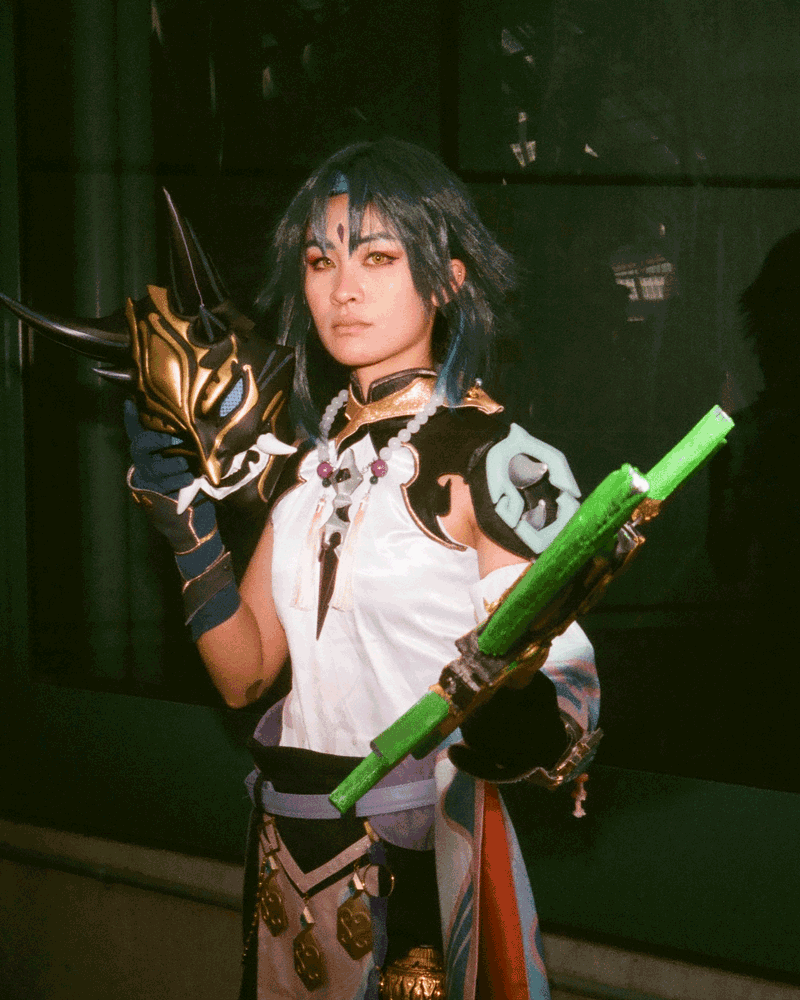 A gif of a woman holding a green weapon in one hand.