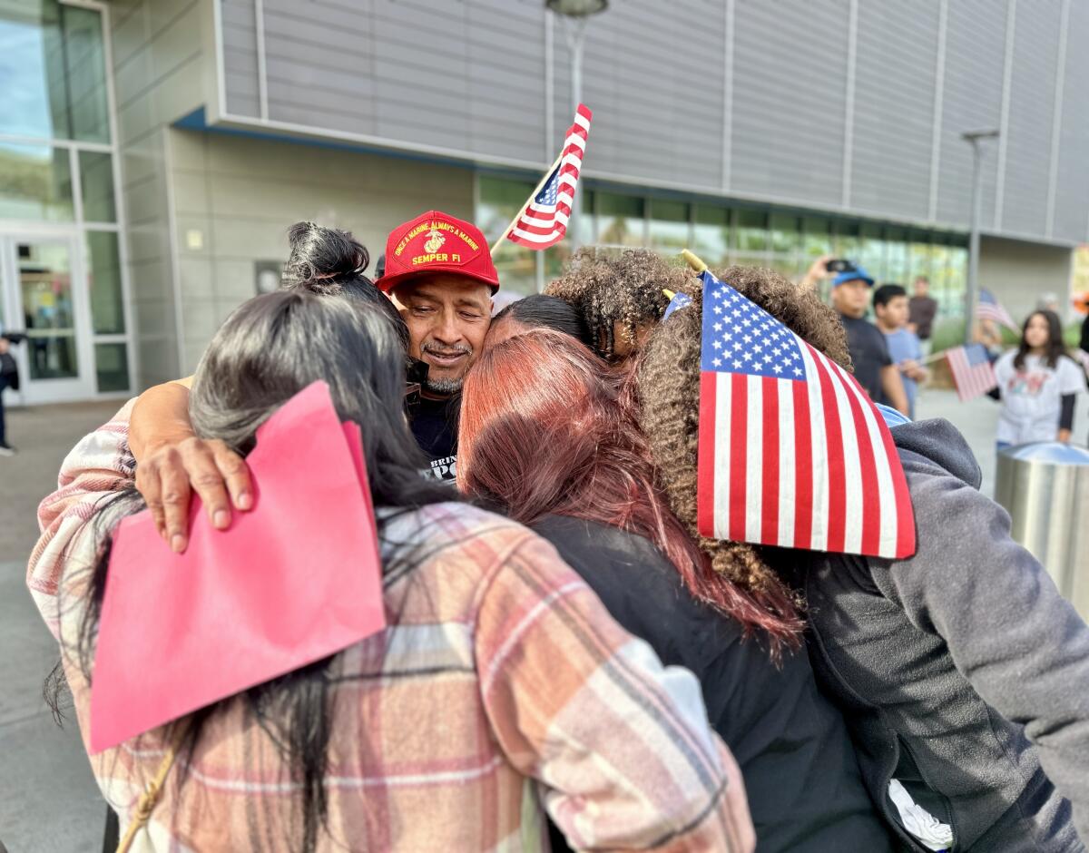 Raúl Orlando Calix hugs his family outside the PedEast crosswalk. Calix returned to the United States after nearly 20 years.