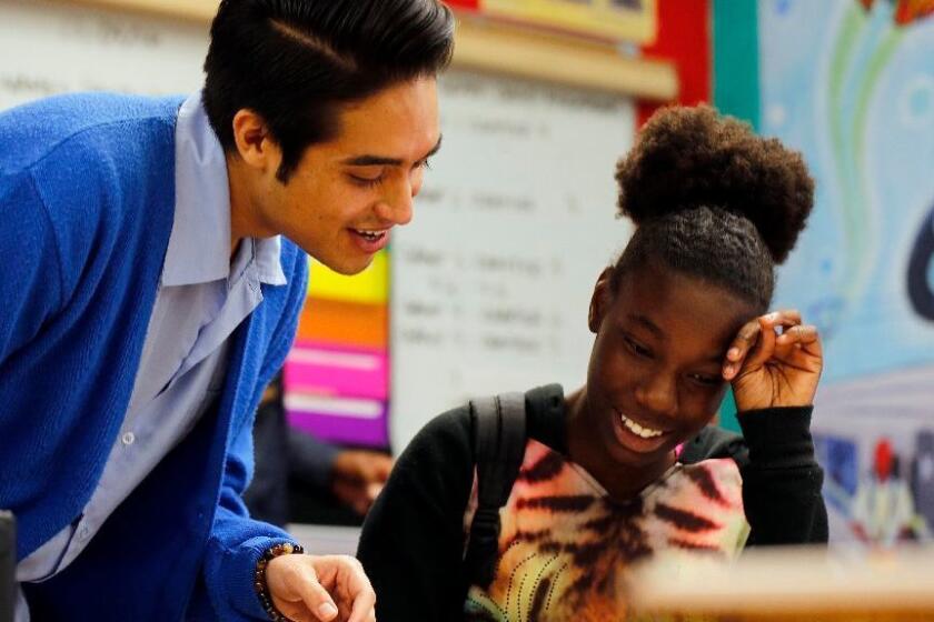 UCLA graduate student Andrew Gutierrez III talks with eighth-grader Avani Green during class at Horace Mann Middle School, which has a new partnership with UCLA and is now called Horace Mann UCLA Community School.