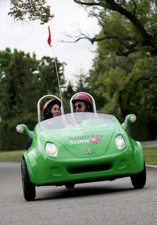 Taylor Kenney, 22 of Los Angeles, rides in the passenger seat of a three-wheel scooter with friend Cameron Sarradet, driving along Griffith Park during a three-hour, Red Carpet tour offered by Sunnyday Scoot on Friday, June 5, 2015.