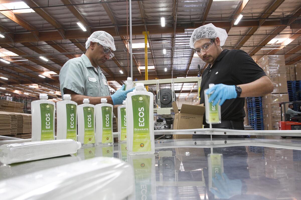 Employees Jamie Rodriguez, left, and Ricardo Barron, box Dishmate at Earth Friendly Products in Cypress on March 16.
