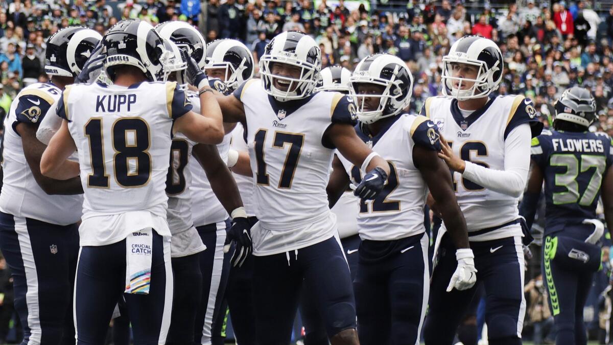 Rams wide receivers Cooper Kupp (18), Robert Woods (17), Brandin Cooks (12) join a celebration after a touchdown against the Seattle Seahawks at CenturyLink Field on Oct. 7, 2018.