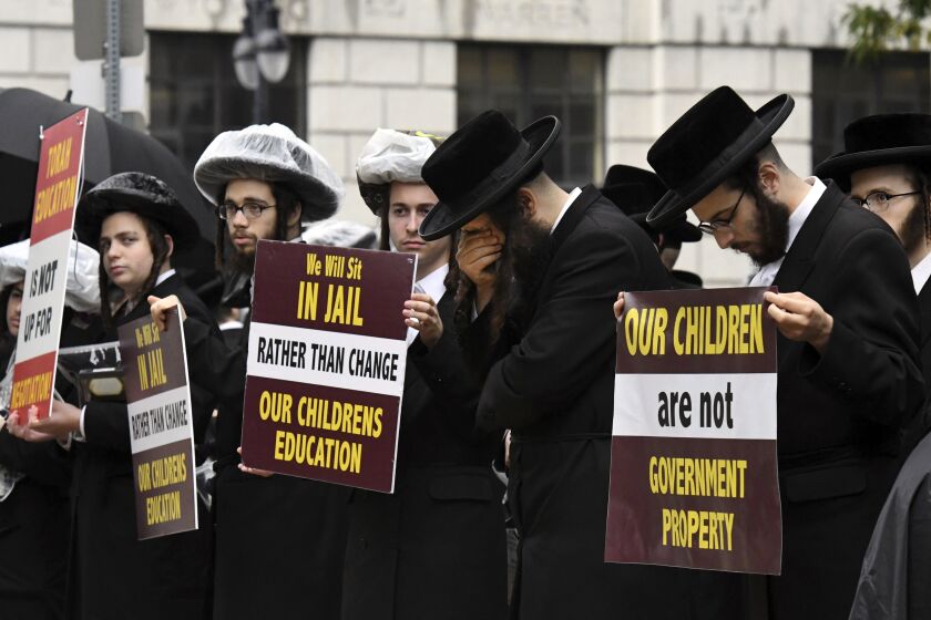 FILE - Members of the ultra-Orthodox and Hasidic Jewish communities protest before a Board of Regents meeting to vote on new requirements that private schools teach English, math science and history to high school students, Sept. 12, 2022, outside the New York State Education Department Building in Albany, N.Y. Parents cannot be required to pull their children from private schools that fail to meet state-designated standards, a judge decided Thursday, March 23, 2022, striking down a key provision of rules recently passed to strengthen oversight of private and religious schools in New York. (Will Waldron/The Albany Times Union via AP, File)