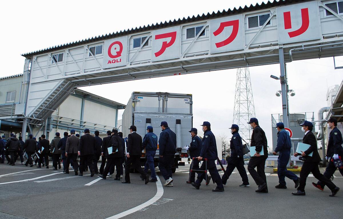 Police investigators enter Aqli Foods, a subsidiary of Japanese food company Maruha Nichiro Holdings, where tainted food is thought to have been made.