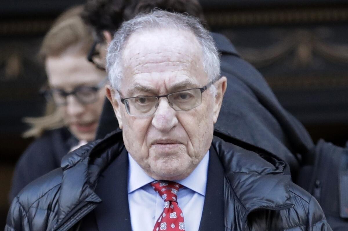 A closeup of Alan Dershowitz in dark parka, suit and tie