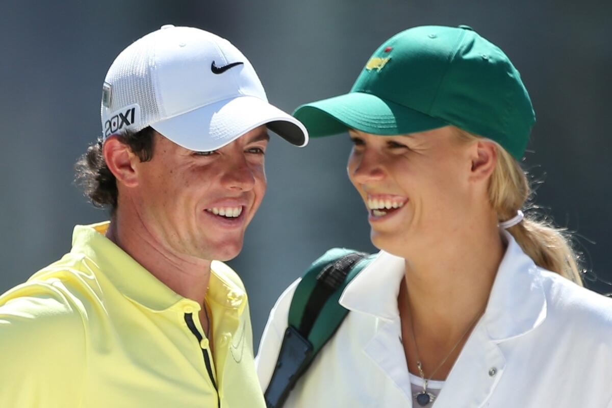 Caroline Wozniacki caddies for Rory McIlroy during the Par 3 Contest prior to the start of the 2013 Masters Tournament at Augusta National in April.