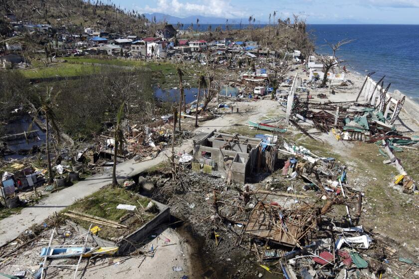 In this photo provided by Greenpeace, damaged homes due to Typhoon Rai lie along a coastal village in Surigao City, southern Philippines Monday Dec. 20, 2021. The governor of a central Philippine province devastated by Typhoon Rai last week pleaded on radio Tuesday for the government to quickly send food and other aid, warning that without outside help, army troops and police forces would have to be deployed to prevent looting amid growing hunger. (Erwin Mascarinas/Greenpeace via AP)