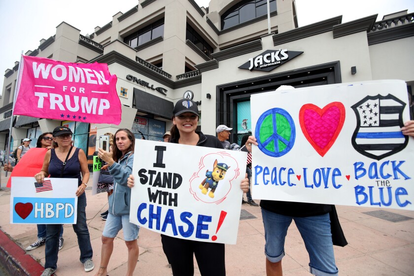 A supporter holds a sign in support of police across the street from a Black Lives Matter rally at Pier Plaza on Saturday.