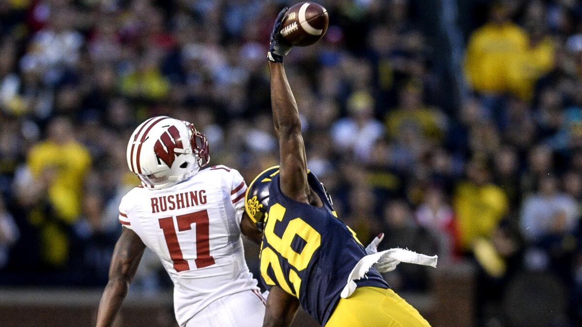 Michigan defensive back Jourdan Lewis makes a one-handed interception on a pass intended for Wisconsin receiver George Rushing in the final minute of the game Saturday.