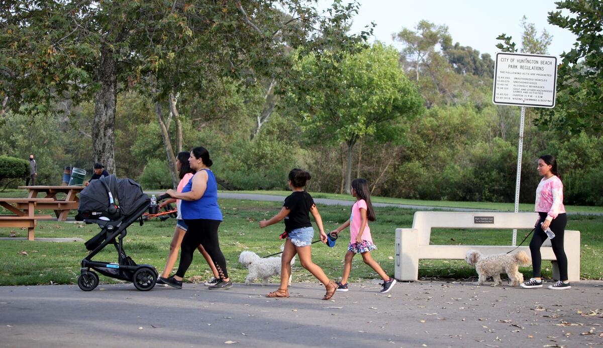 A woman and her children get some exercise at Central Park in Huntington Beach on Friday.