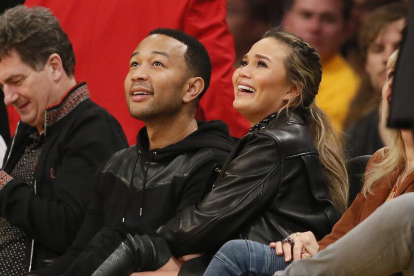 John Legend and Chrissy Teigen sit courtside for the final Kobe Bryant-LeBron James matchup on March 10, 2016, at Staples Center.