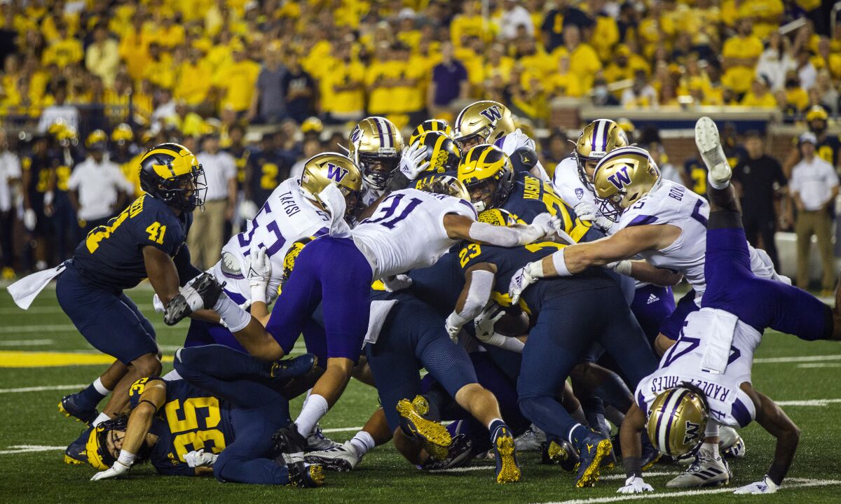 Michigan linebacker Michael Barrett (23) rushes with a fake punt to convert on a fourth down in the second quarter of an NCAA college football game against Washington in Ann Arbor, Mich., Saturday, Sept. 11, 2021. (AP Photo/Tony Ding)