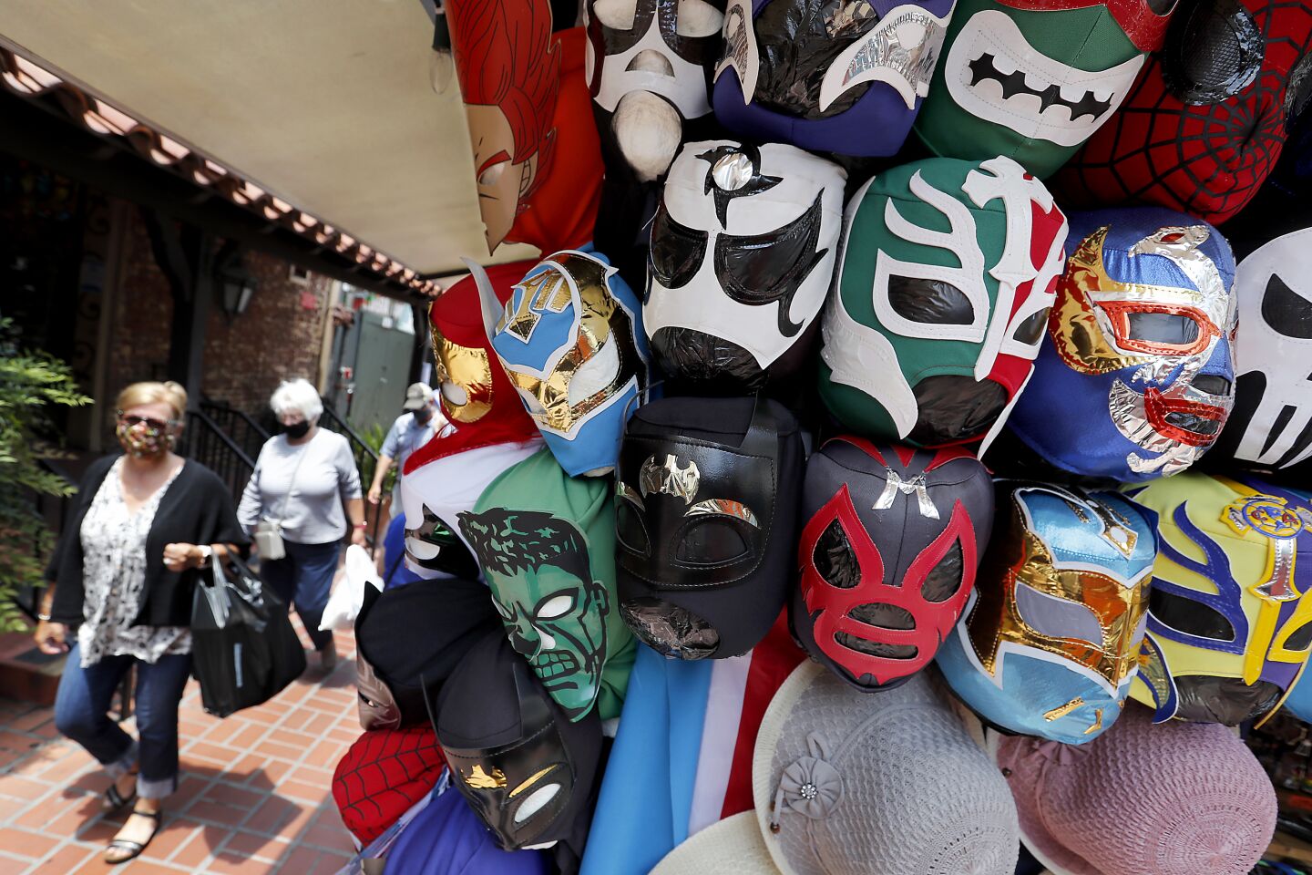 Visitors wear protective masks while walking through historic Olvera Street in downtown Los Angeles on Thursday.
