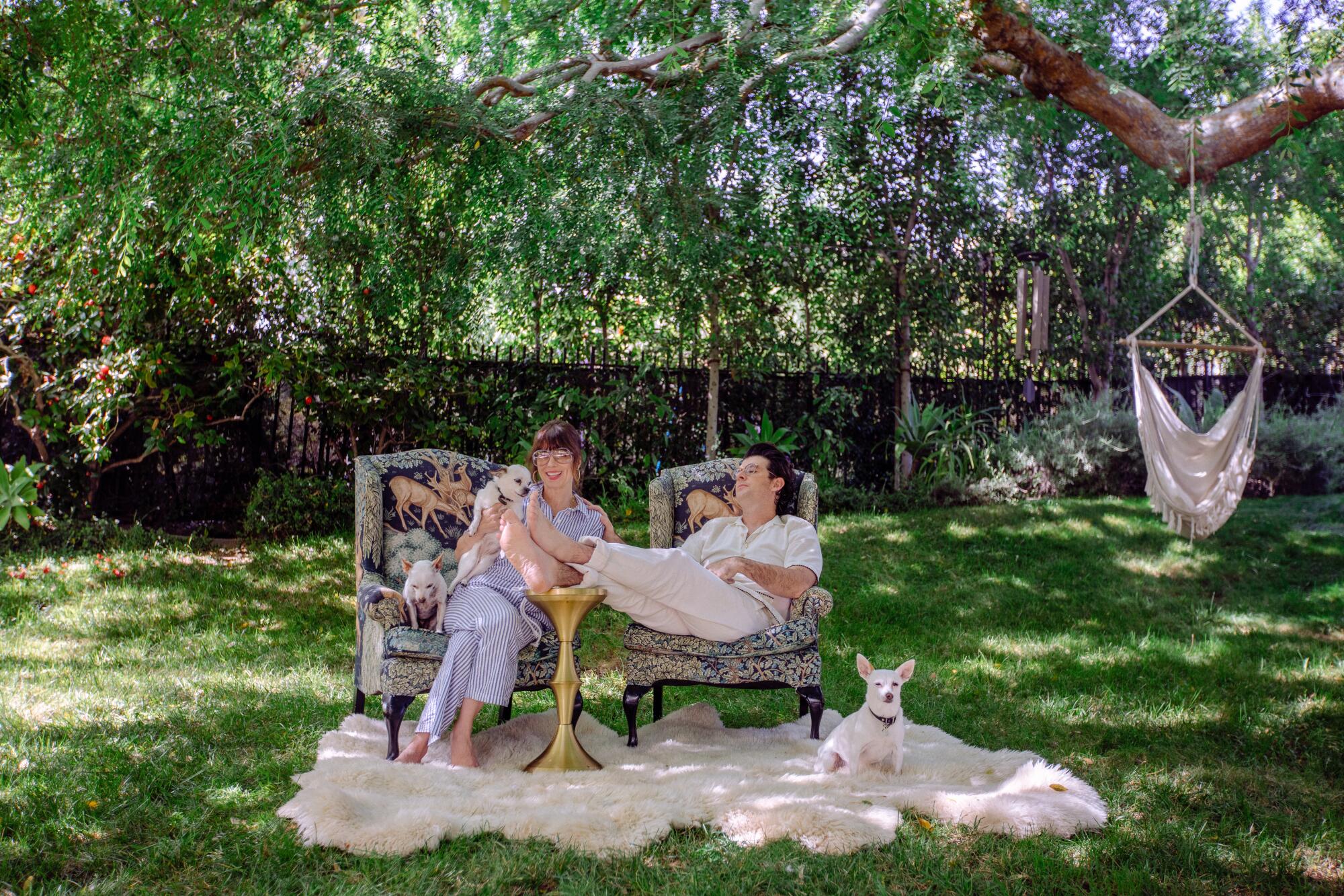  Couple lounges outside on chairs with dog