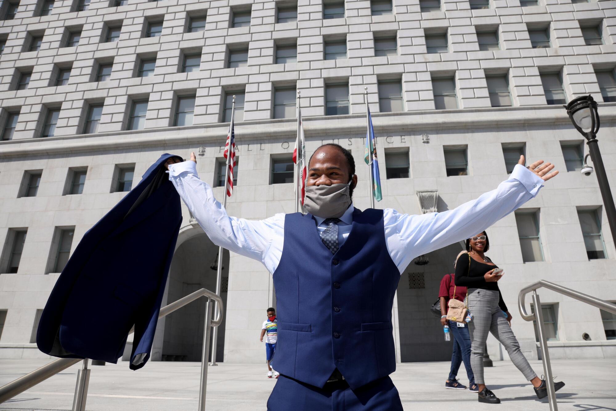 Derrick Harris raises his arms outside the Hall of Justice in Los Angeles.