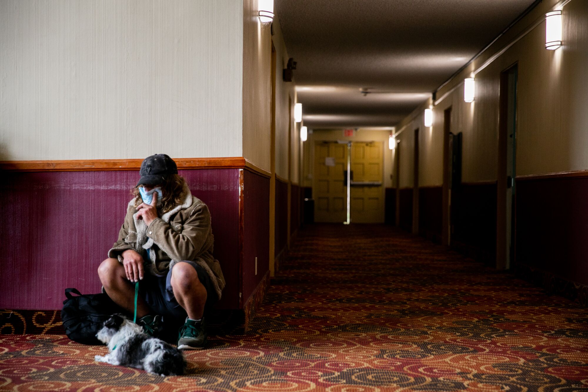 Michael Vorgang and his dog Moo Moo wait to be processed before being placed in a hotel room 