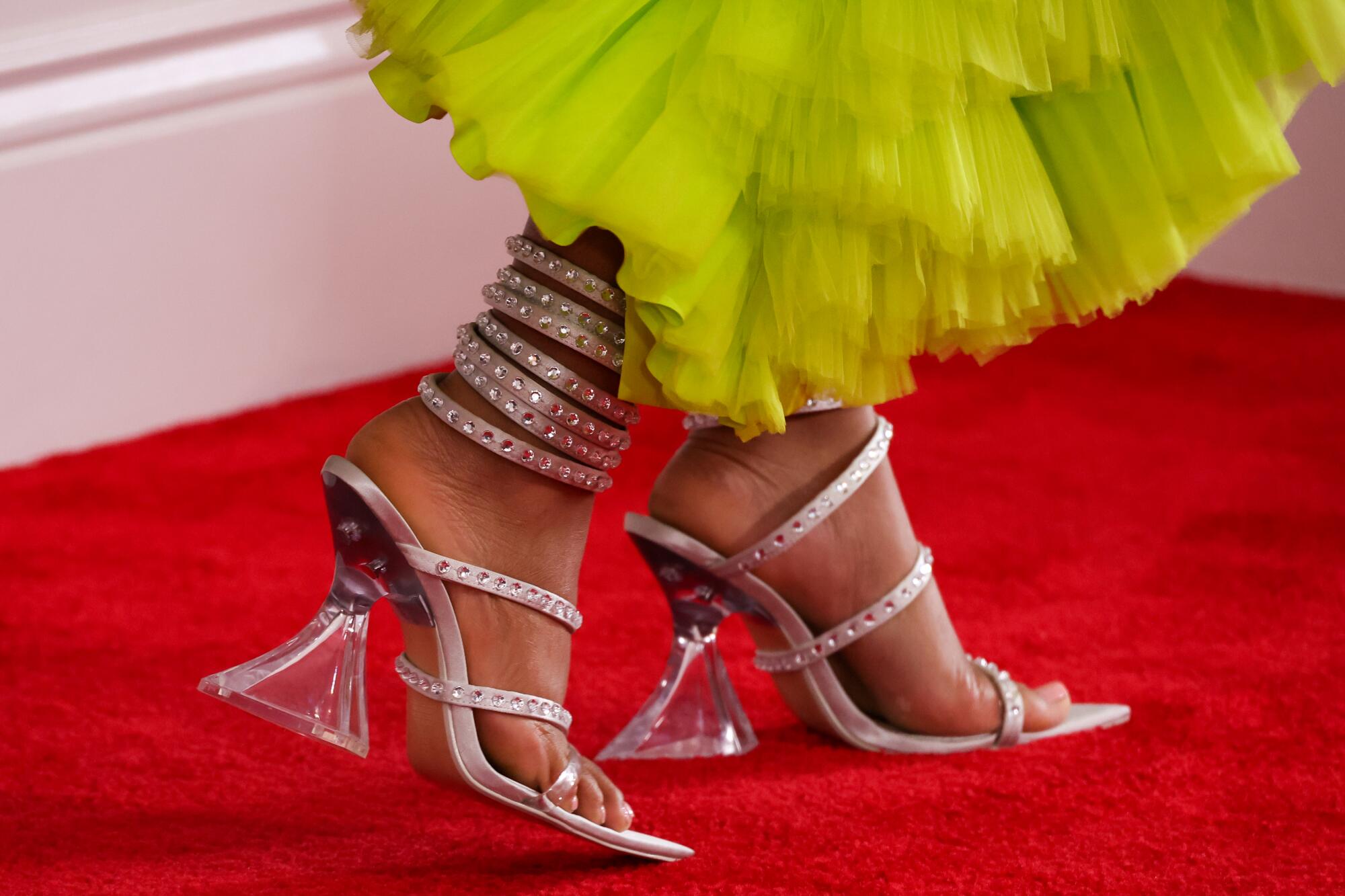 Close-up of high heel shoes and yellow dress hem 