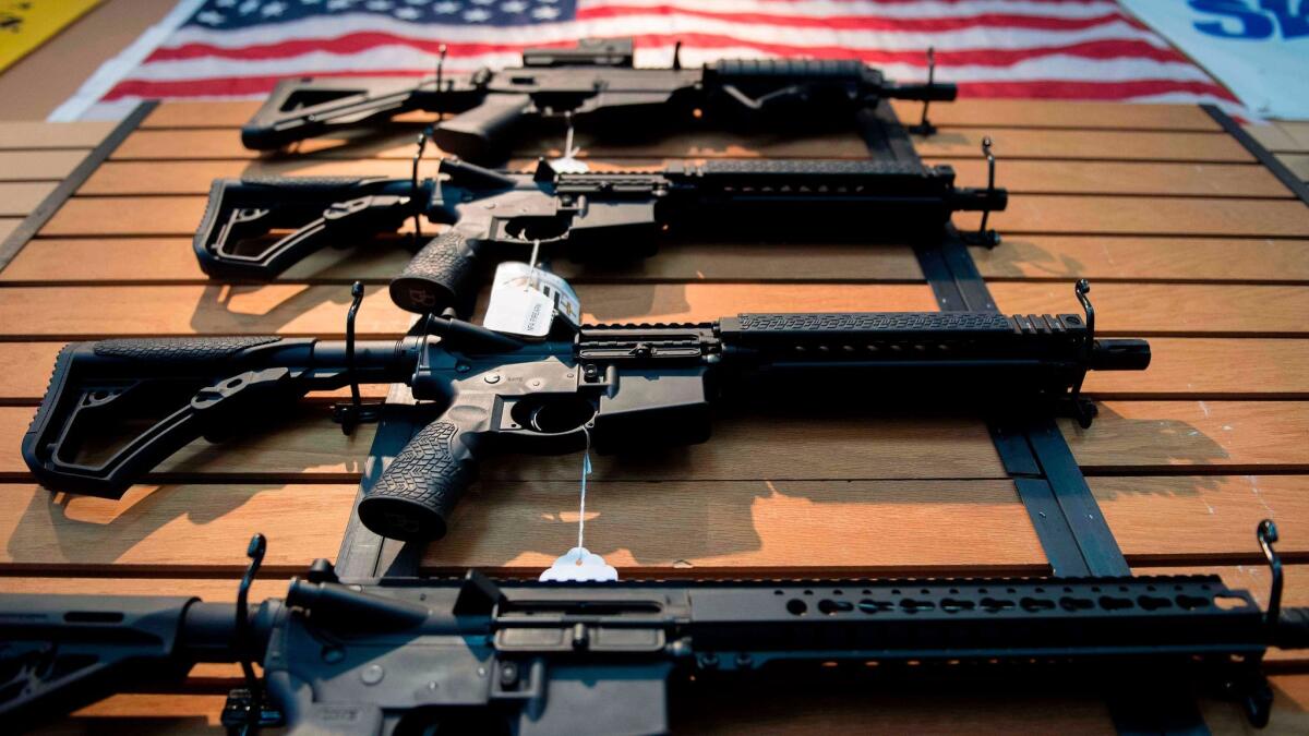 Assault rifles hang on the wall for sale at Blue Ridge Arsenal in Chantilly, Va., on Oct. 6.
