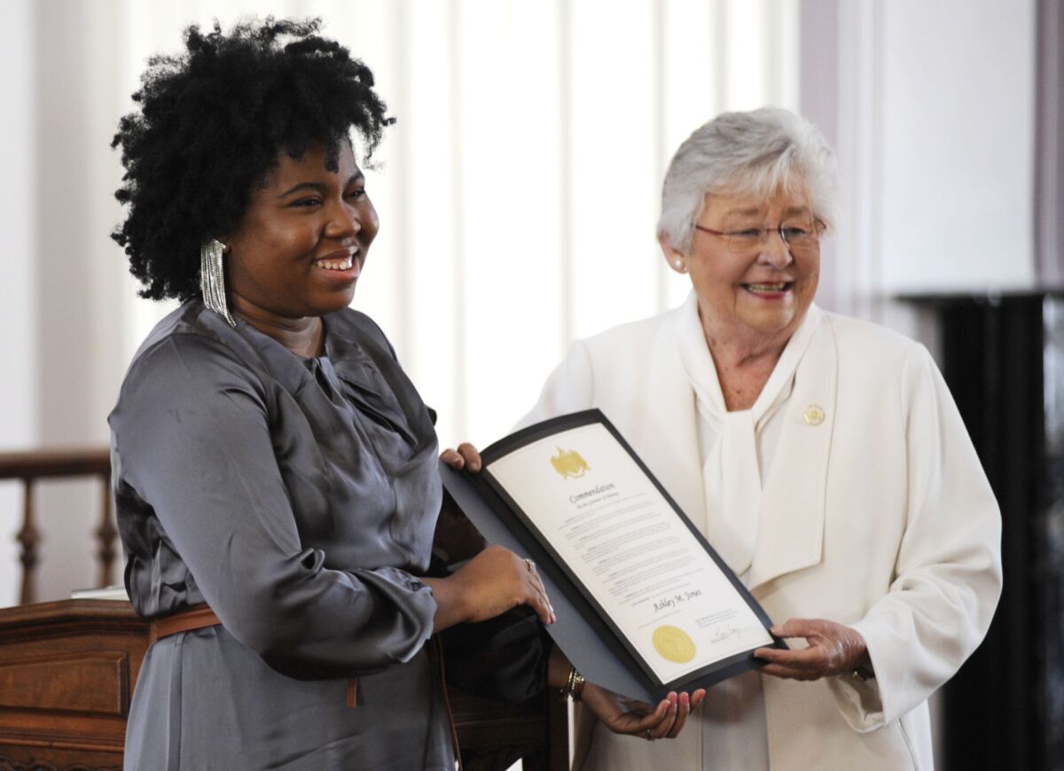 Alabama Gov. Kay Ivey presents a commendation to the state's first Black poet laureate, Ashley M. Jones, during a ceremony at the Capitol in Montgomery, Ala., on Wednesday, Dec. 1, 2021. Jones, a creative writing teacher from Birmingham, delves into the pain and difficulty of being Black in America. Her most recent book is a collection of poems titled "Reparations Now!" (AP Photo/Jay Reeves)