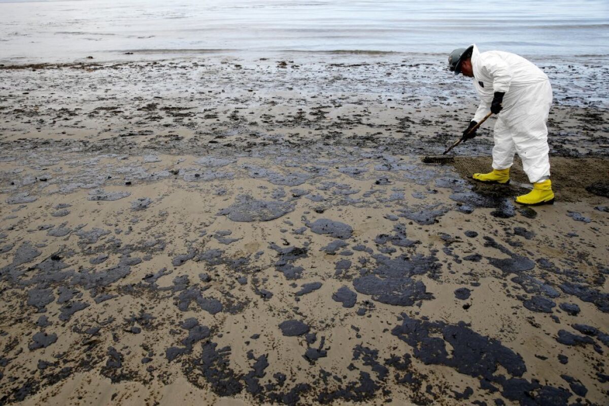 FILE - In this May 21, 2015 file photo, a worker removes oil from the sand at Refugio State Beach in the Santa Barbara Channel, north of Goleta, Calif., as cleanup work continues one month after the May 19 oil spill north of Santa Barbara, Calif.