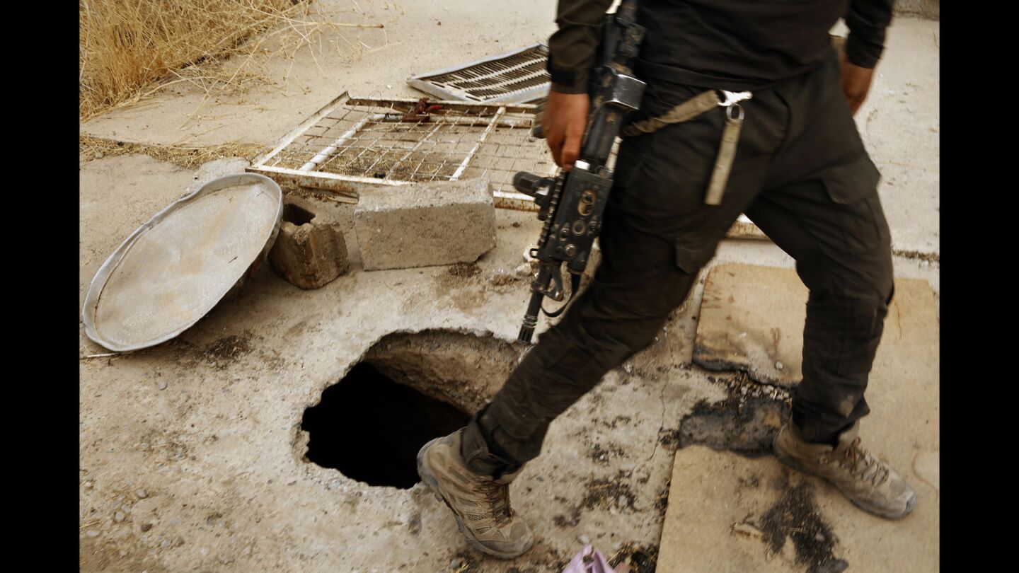 An Iraqi special forces member notes the entrance to a tunnel dug by Islamic State forces in the town of Bartella.