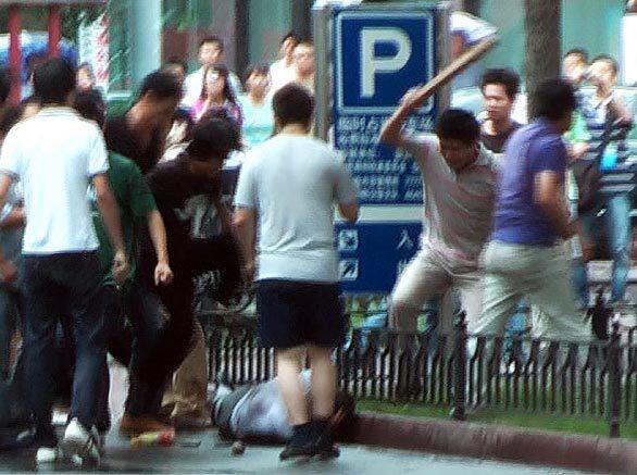 An image taken from video shows a mob of Han Chinese attacking a lone ethnic Uighur along a street in Urumqi, in China's far west Xinjiang province. Han Chinese mobs attacked two Uighurs in separate incidents in Urumqi, according to AFP reporters.