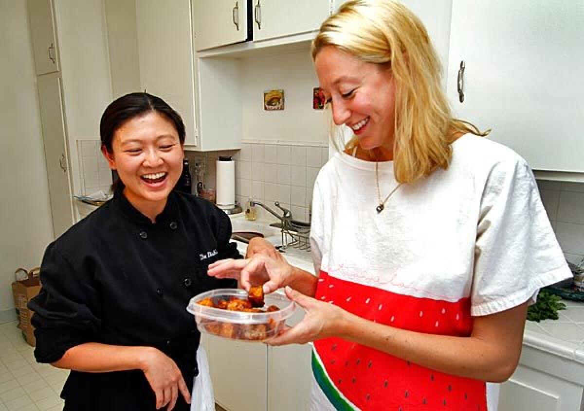 Personal chef Linda Wong, left, gives a hand to Dishs Dish founder Jill Donenfeld.