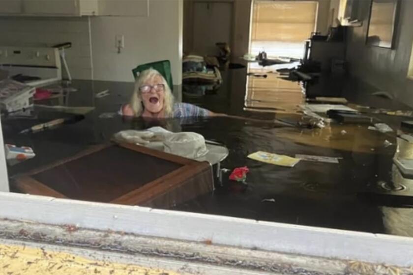 In this photo provided by Johnny Lauder, Lauder's mother, Karen Lauder, 86, is submerged nearly to her shoulders in water that has flooded her home, in Naples, Fla., Wednesday, Sept. 28, 2022, following Hurricane Ian. (Johnny Lauder via AP)