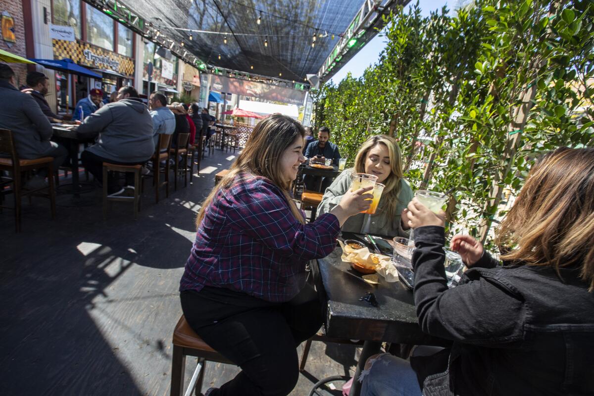 Limon y Sal guests from left, Alexa Lona, Daniela Villa and Amber Bolo enjoys drinks on the street side patio in Ventura.