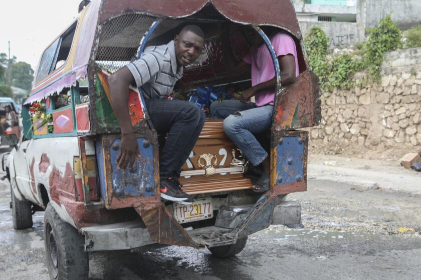 La gente transporta un ataúd en un taxi público 