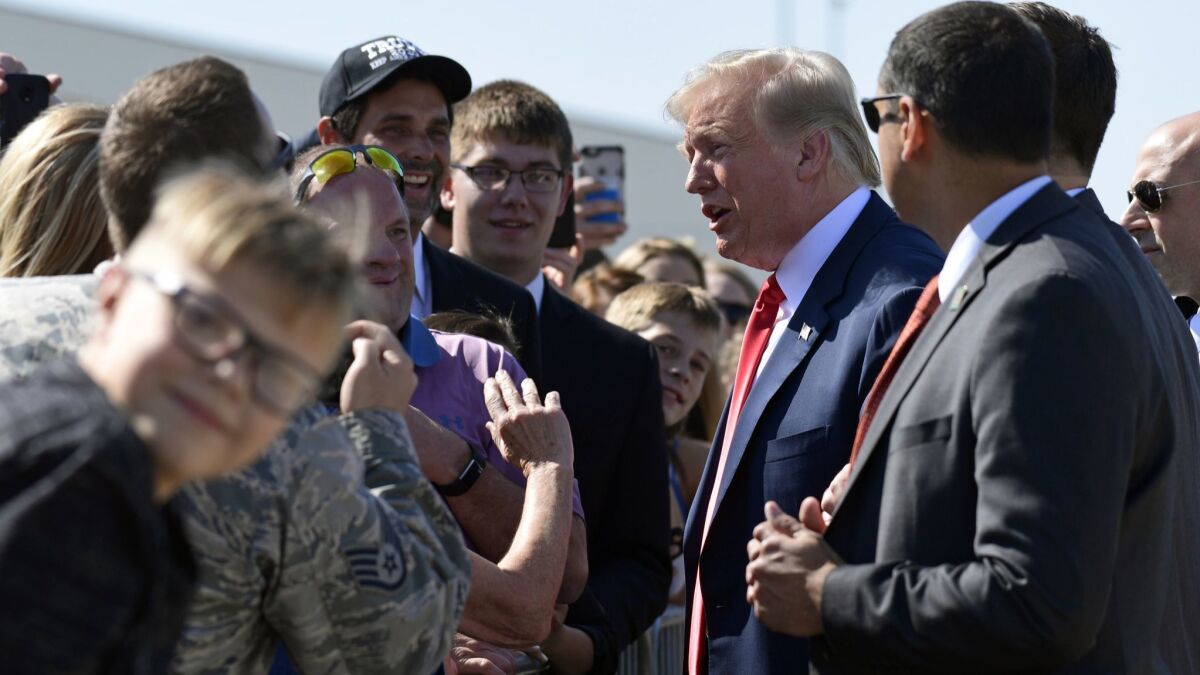President Trump greets people Friday at an airport in Sioux Falls, S.D., where he landed after a visit to North Dakota.