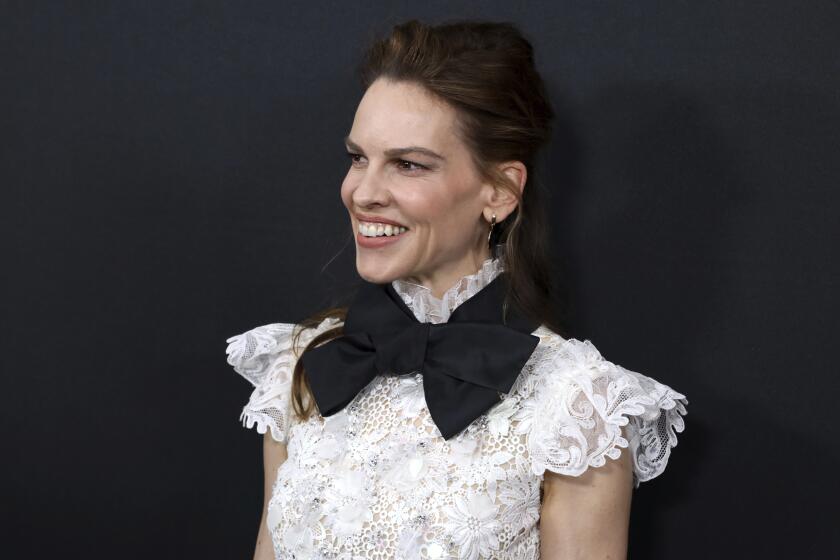 Hilary Swank smiles in white lace top and oversized black bow tie at LA Special Screening of "The Hunt" 