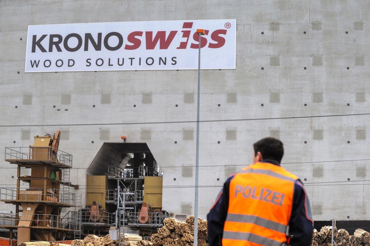 A police officer stands on Wednesday outside the Kronoswiss wood panel plant in Menznau, near Lucerne, where three people were killed when a gunman opened fire earlier in the day.