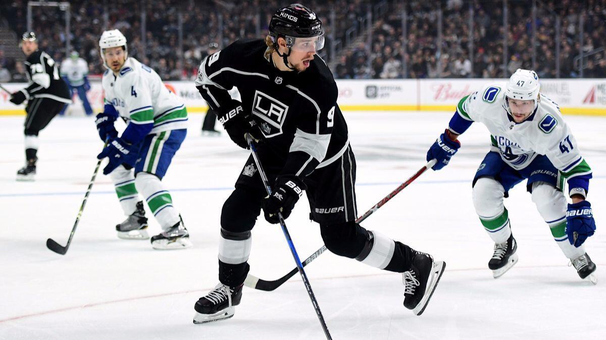 The Kings' Adrian Kempe (9) controls the puck in front of the Vancouver Canucks' Sven Baertschi (47) and Michael Del Zotto (4) during the first period at Staples Center on Nov. 14.
