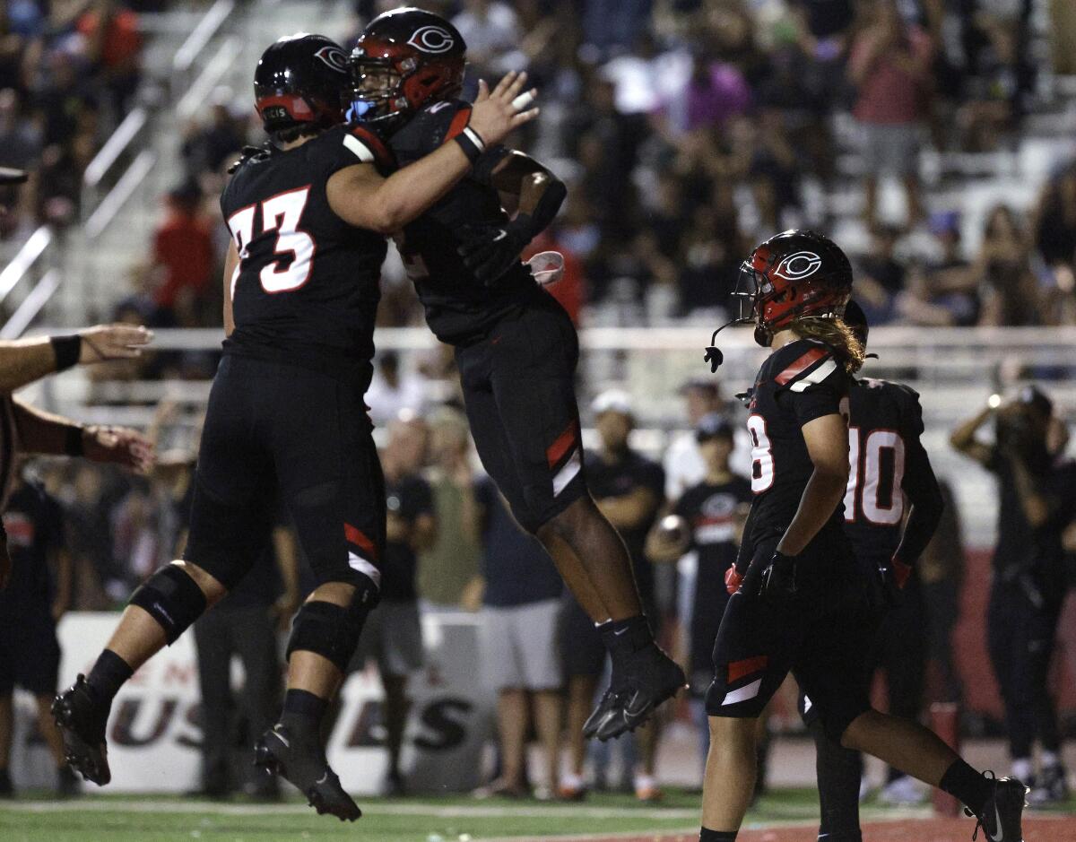 Centennial running back Cornell Hatcher, Jr., right, celebrates with Wade Helton