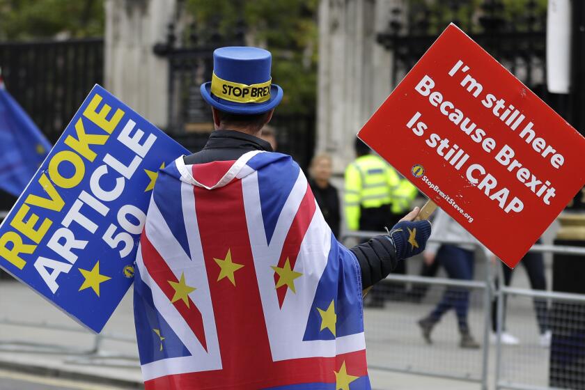 Anti-Brexit campaigner Steve Bray walks near Parliament in London, Tuesday, Oct. 8, 2019. The British government said Tuesday that the chances of a Brexit deal with the European Union were fading fast, as the two sides remained unwilling to shift from their entrenched positions. (AP Photo/Kirsty Wigglesworth)