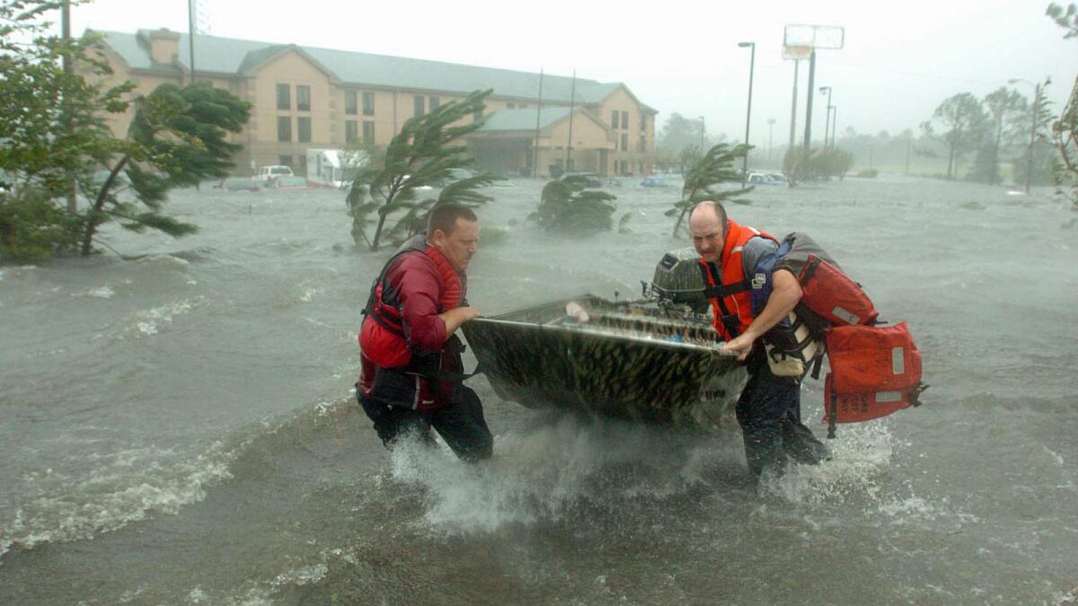Fire and rescue personnel head out to save a family trapped by Hurricane Katrina in Pascagoula, Miss.
