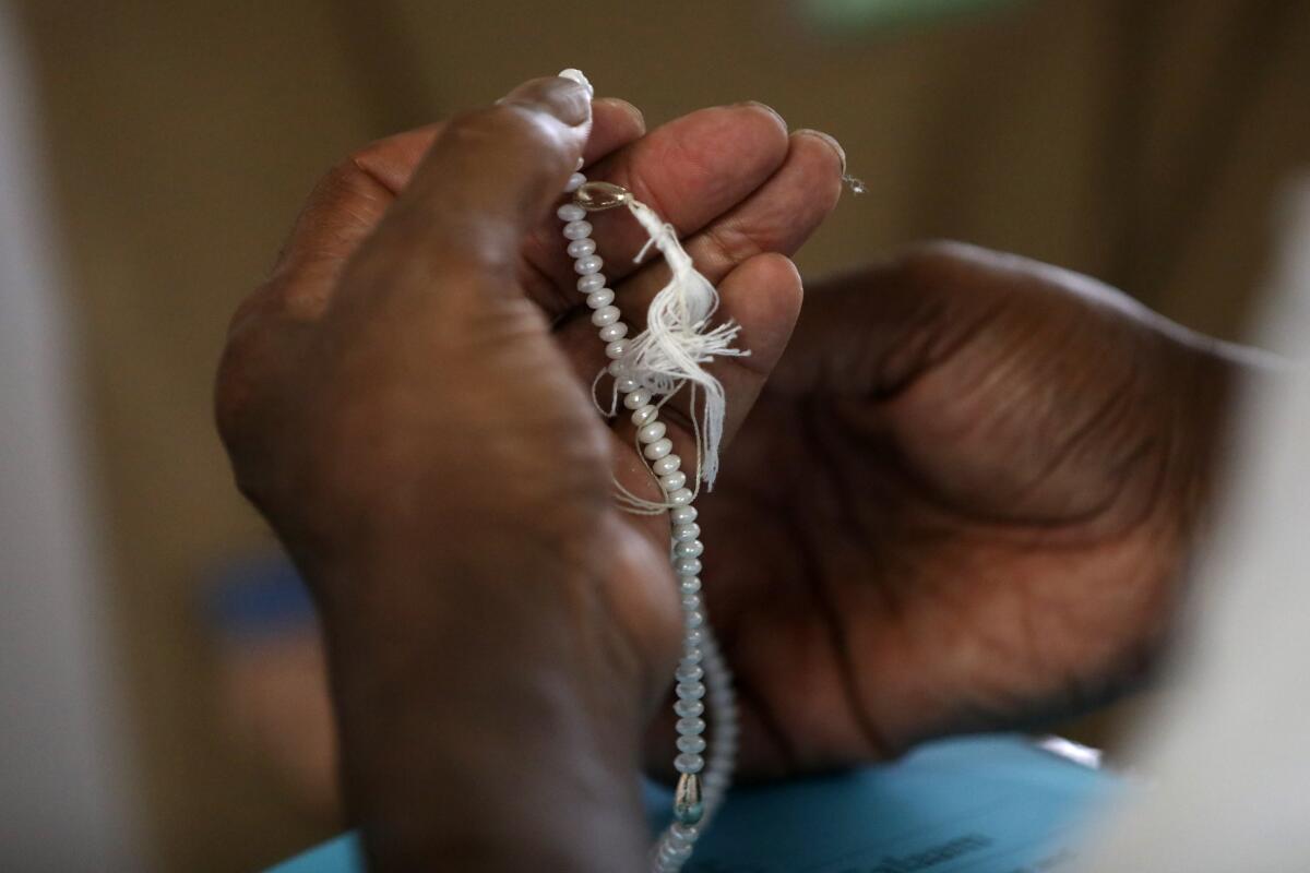 An inmate receives prayer beads from Maria Khani, a Muslim chaplain, at Twin Towers Correctional Facility. (Gary Coronado / Los Angeles Times)