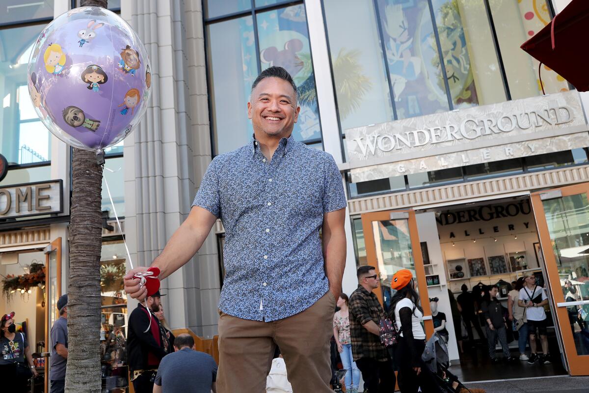Artist Jerrod Maruyama, 50, of Irvine, holds a balloon with his animation at Disney's WonderGround Gallery.