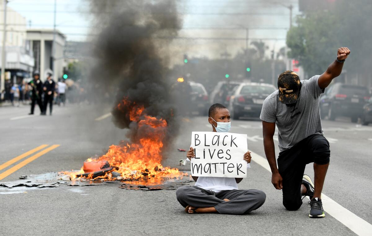 Protesters sit along 3rd Street in the Fairfax District of Los Angeles.