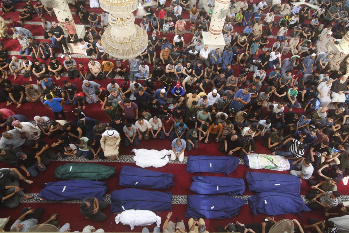 ARCHIVO - Dolientes rezan junto a los cadáveres de los familiares de Salem Abu Quta, 