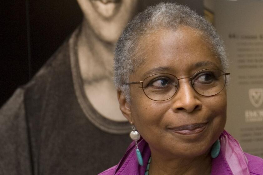FILE - In this April 23, 2009 file photo, Alice Walker stands in front of a picture of herself from 1974 as she tours her archives at Emory University, in Atlanta. Walker and The New York Times are drawing fire after she praised an author who critics say is a conspiracy theorist who expresses anti-Semitism. In an interview in Sundays By The Book column, the author of The Color Purple said David Ickes 1995 book, And The Truth Shall Set You Free, is on her nightstand. A New York Times spokesperson says the column is not a list of recommendations from its editors. (AP Photo/John Amis, File)