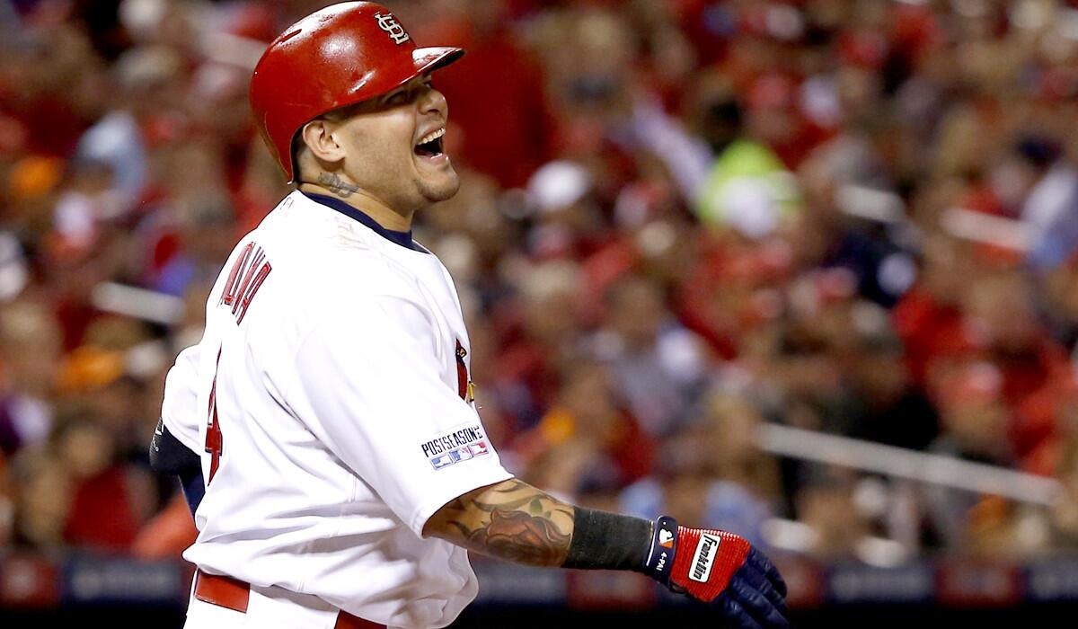 Cardinals catcher Yadier Molina grimaces after straining his left oblique muscle while taking a swing in Game 2 of the NLCS on Sunday in St. Louis.