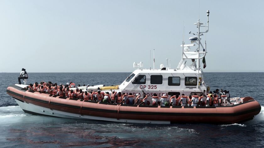 Some migrants who had been aboard the rescue ship Aquarius are transferred Tuesday to Italian Coast Guard boats in the Mediterranean Sea. Italy refused to allow the rescue ship with 629 migrants to dock and is now helping transport some of them to Spain, days away by sea.
