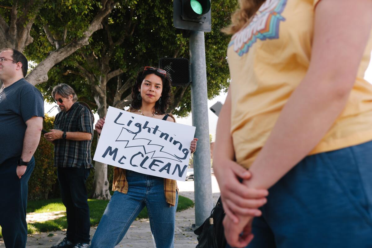 A woman holds a "Lightning McClean" sign.