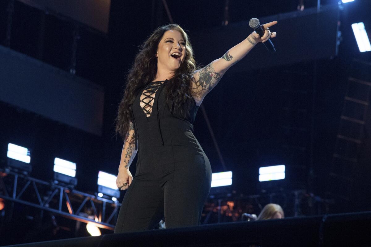 A female country singer performs onstage