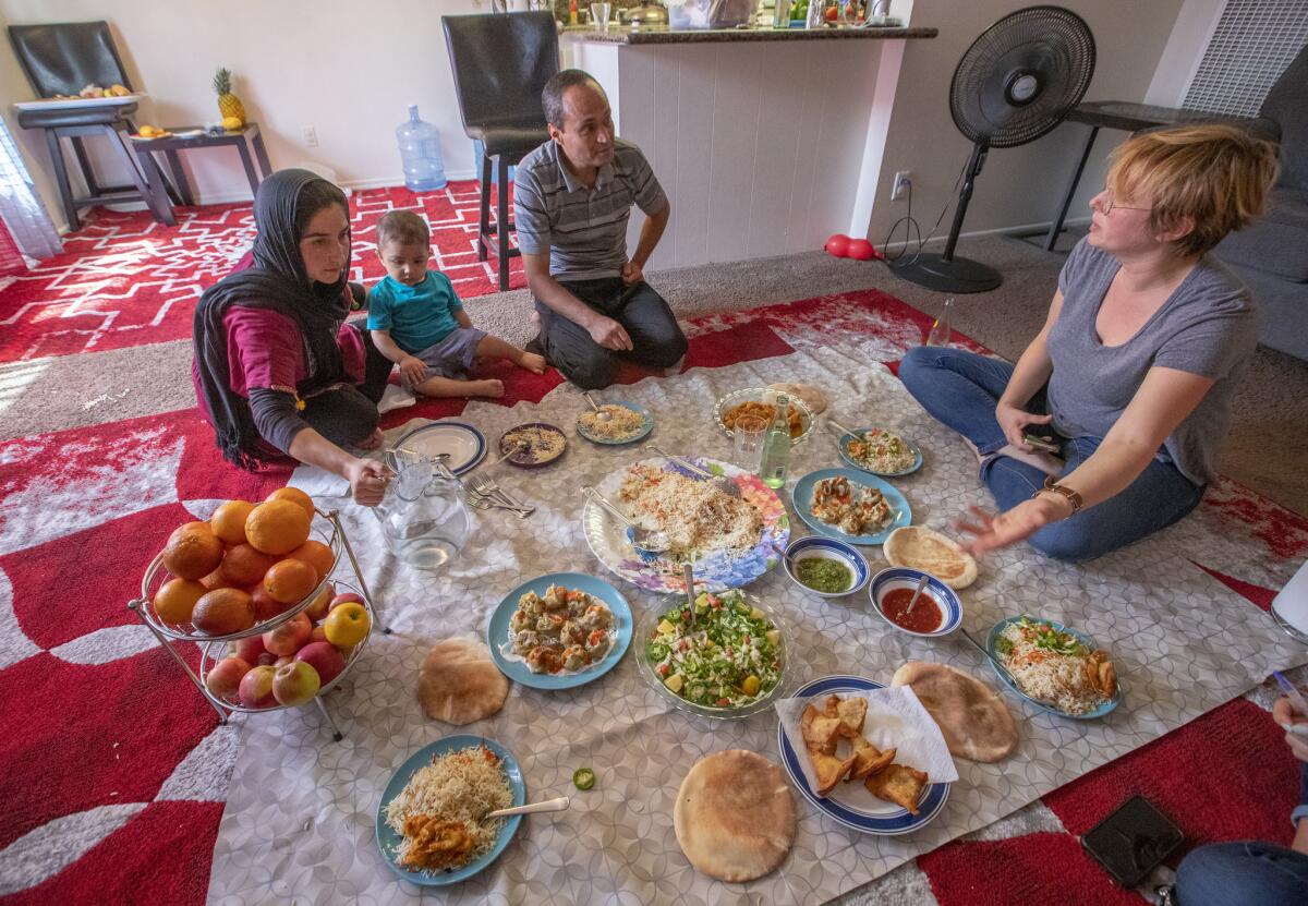 Naseema Kashefi, left, cooked Afghan food for her son, Haroon, 2, husband, Bashir, and Miry Whitehill, right, founder of Miry's List. (Allen J. Schaben / Los Angeles Times)